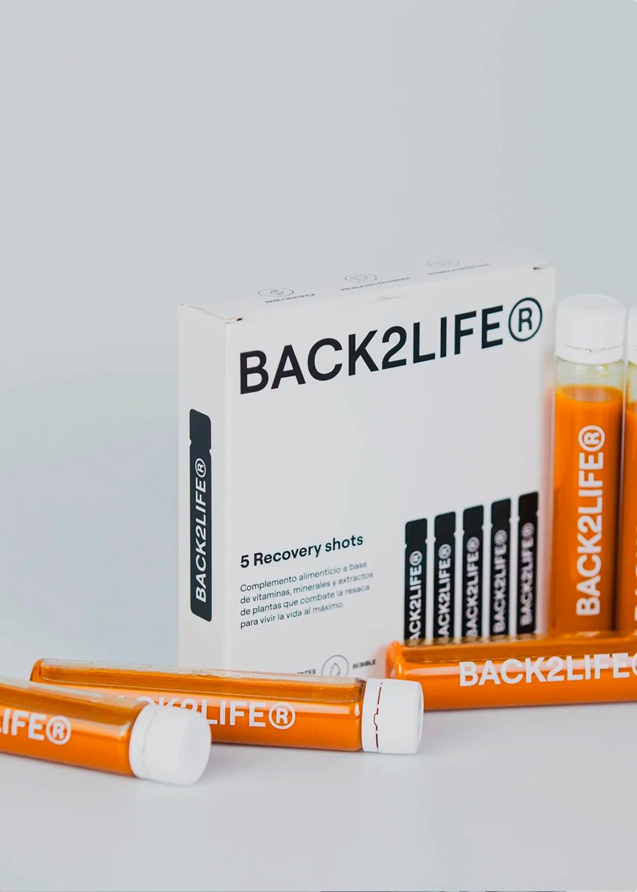 Caja de complementos alimenticios BACK2LIFE con frascos de recuperación en primer plano.