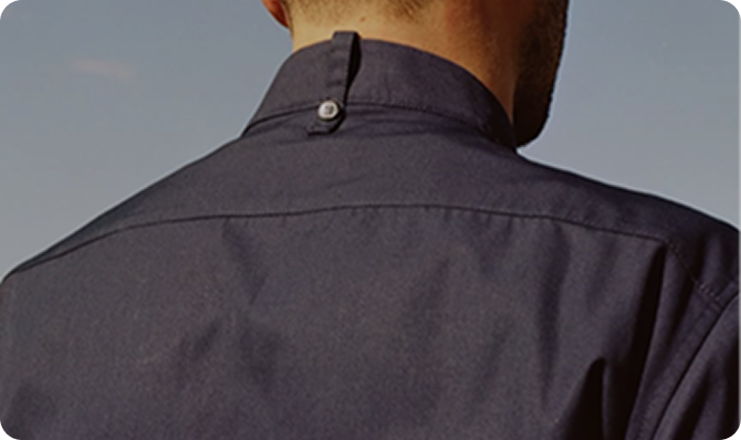Hombre de espaldas con camisa azul, fondo de cielo despejado, ideal para agencia Shopify.